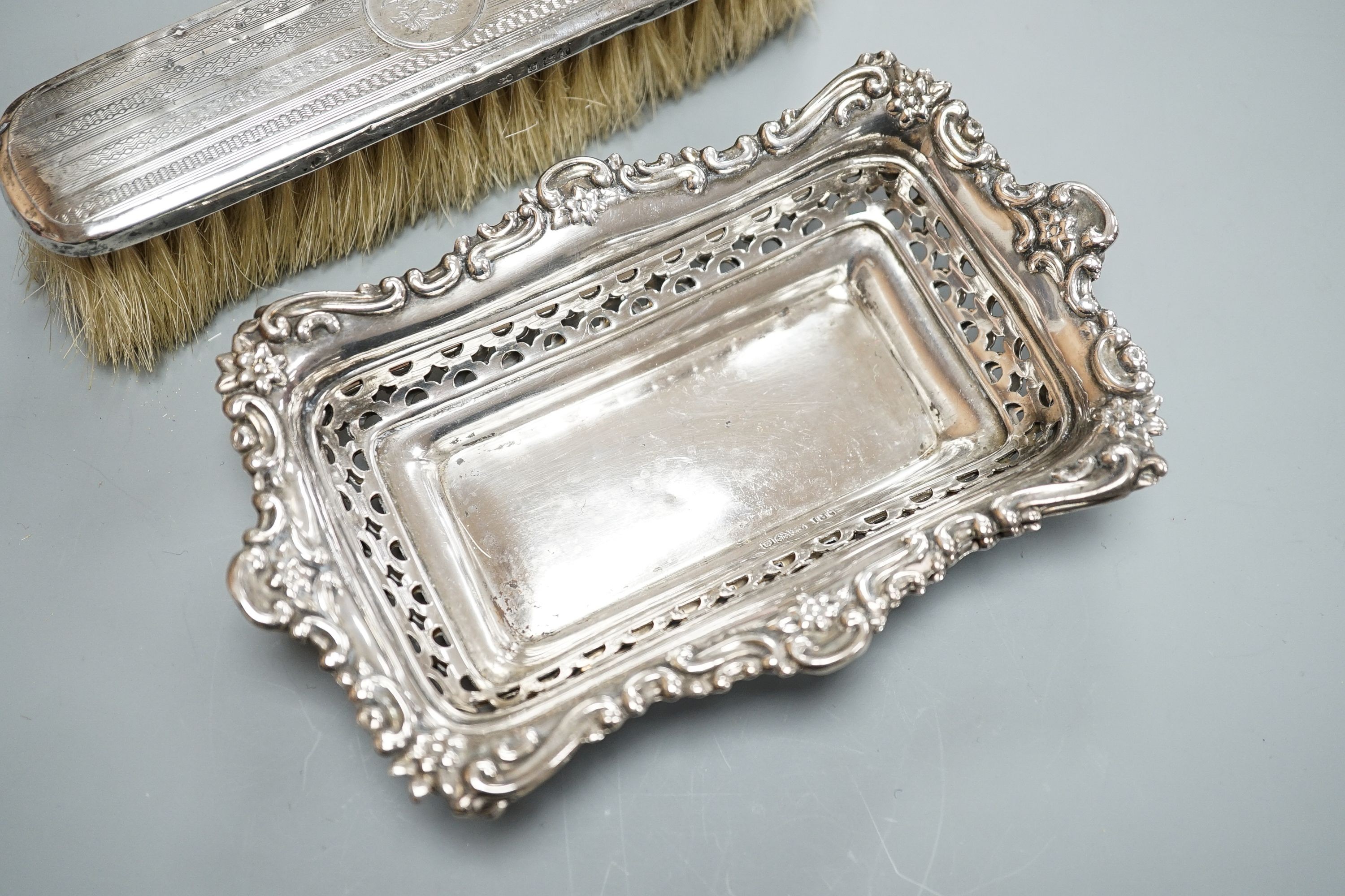 A pair of Edwardian pierced silver bonbon dishes, Chester, 1902, 16.1cm, 4.5oz, a silver and mother of pearl fruit knife, silver cased penknife and silver mounted clothes brush and a modern silver cased pocket torch.